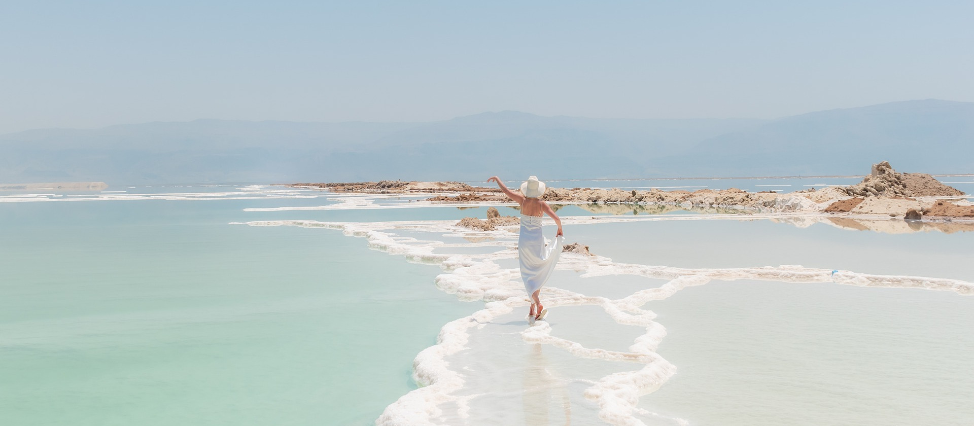 Woman walking along salt beds of the Dead Sea in Israel.